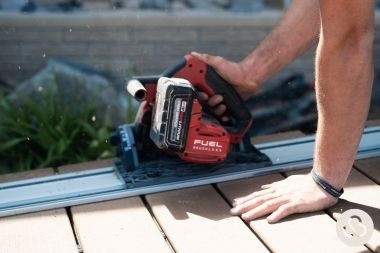 composite deck builder sawing deck board for Custom Built Design and Remodeling