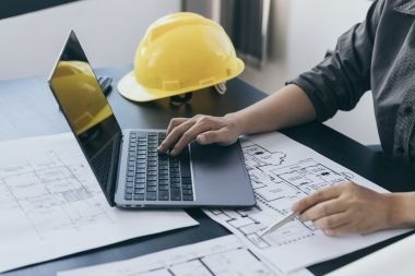 Greater Lansing composite deck builder with laptop and design blueprints