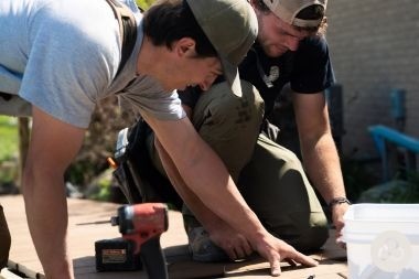 Greater Lansing composite deck builders installing decking boards for Custom Built Design and Remodeling