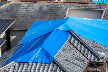 how to address a roof leak if it happens blue tarps draped on open roofing patches custom built michigan