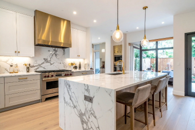 how to decide where to put features in your kitchen remodeling project waterfall island and stone slab backsplash custom built michigan