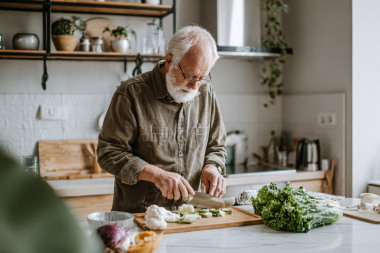 how to decide where to put features in your kitchen remodeling project elderly homeowner preparing meal at island custom built michigan