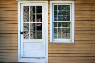 Greater Lansing home with outdated door and window