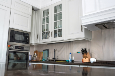 Greater Lansing kitchen remodeling project with tile backsplash and glass front cabinet