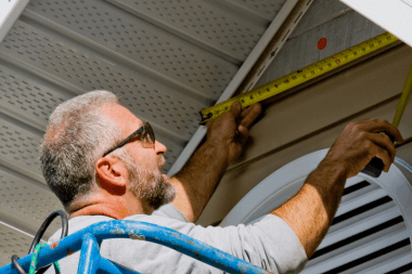 Greater Lansing siding installer measuring side of home