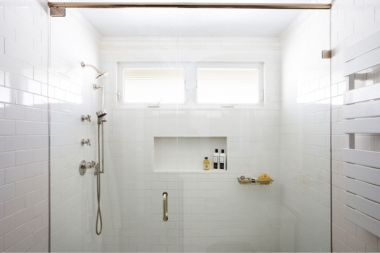Greater Lansing basement bathroom with transom windows and shower glass door enclosure