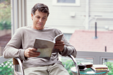 sunroom addition cost vs roi is it a smart investment homeowner reading book in four seasons room custom built michigan