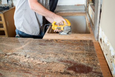 how inspection affect your home remodeling project timeline contractor sawing wood for kitchen sink area custom built michigan