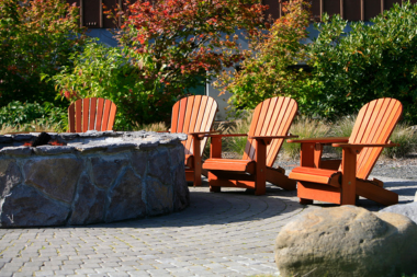 landscaping renovations to plan now for summer enjoyment stone fire pit area with adirondack chairs custom built michigan