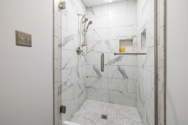 bathroom remodel cost myths every homeowner should know shower with glass door and gray wall tiles custom built michigan
