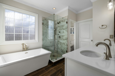 bathroom remodel cost myths every homeowner should know large freestanding bathtub next to glass shower and double sink vanity custom built michigan