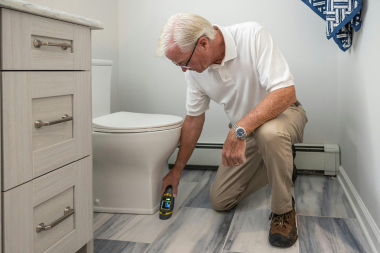 bathroom remodel cost myths every homeowner should know inspector measuring toilet in finished space custom built michigan