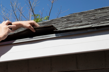 ultimate michigan roof maintenance guide roofing contractor inspecting shingles and gutter custom built okemos
