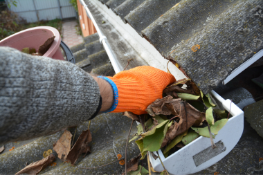 ultimate michigan roof maintenance guide roofing contractor clearing leaves and debris from gutters custom built okemos
