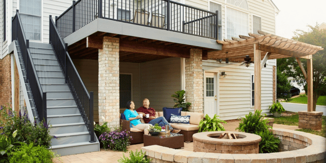 combining hardscaping and decking for a unique outdoor living space multi level deck with stone fire pit custom built michigan