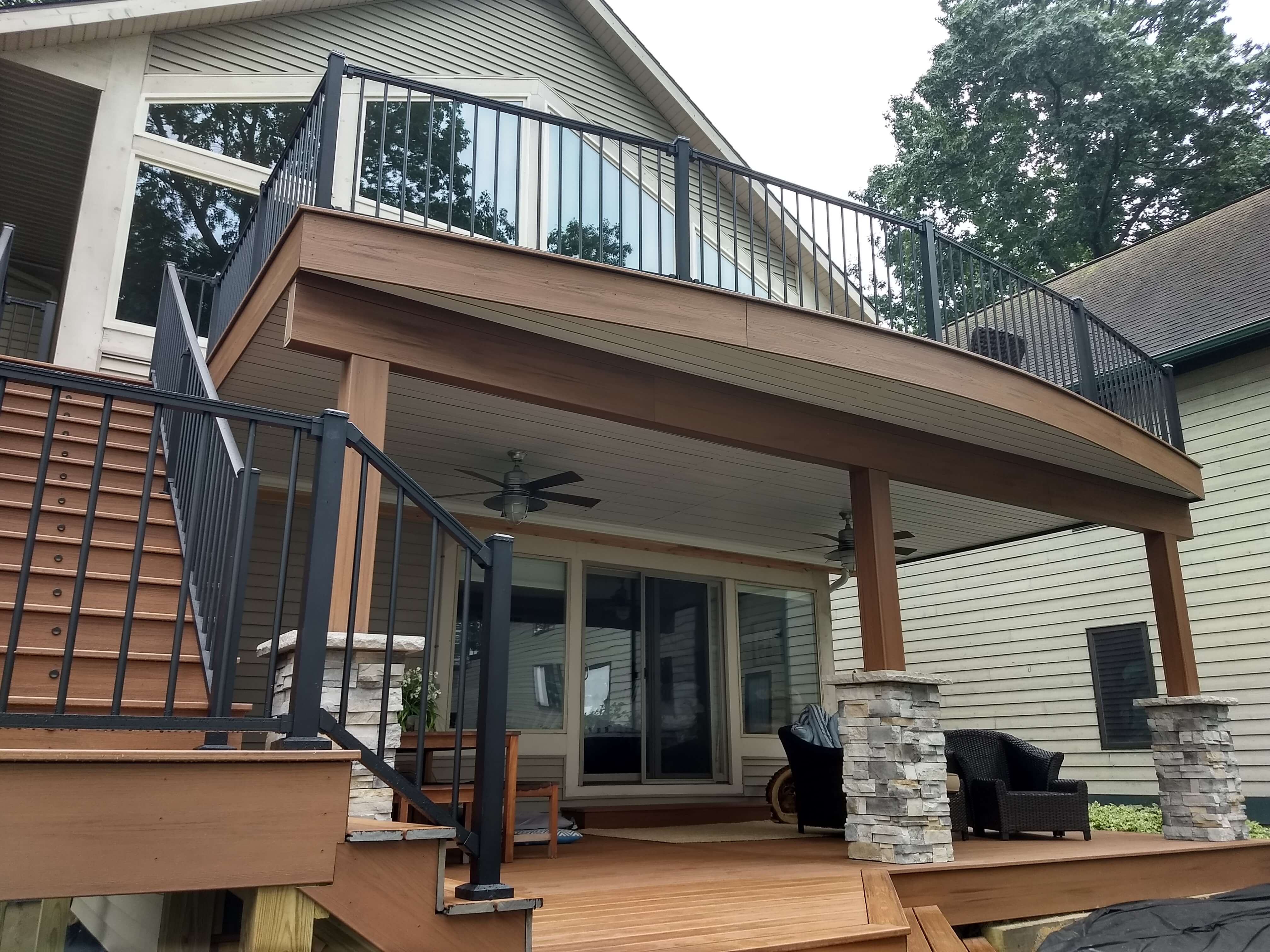 2 story deck with rock posts and brown fascia