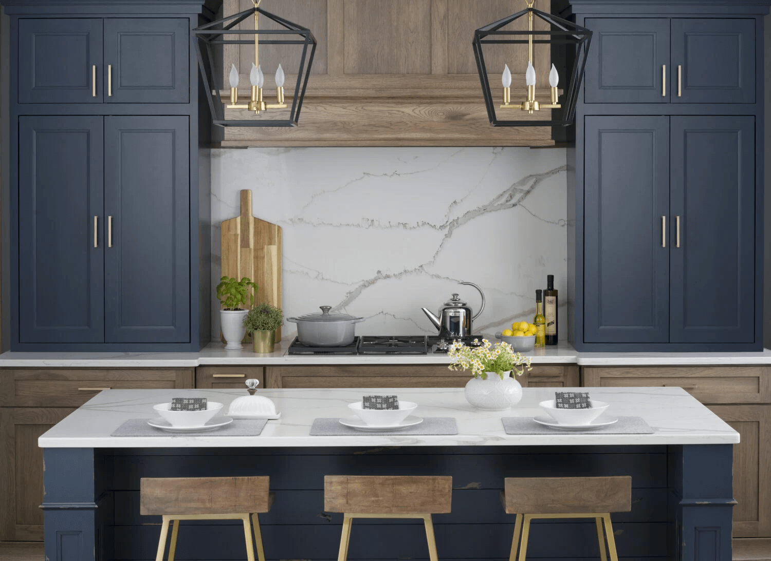 Dark blue kitchen cabinets and a natural stone slab backsplash
