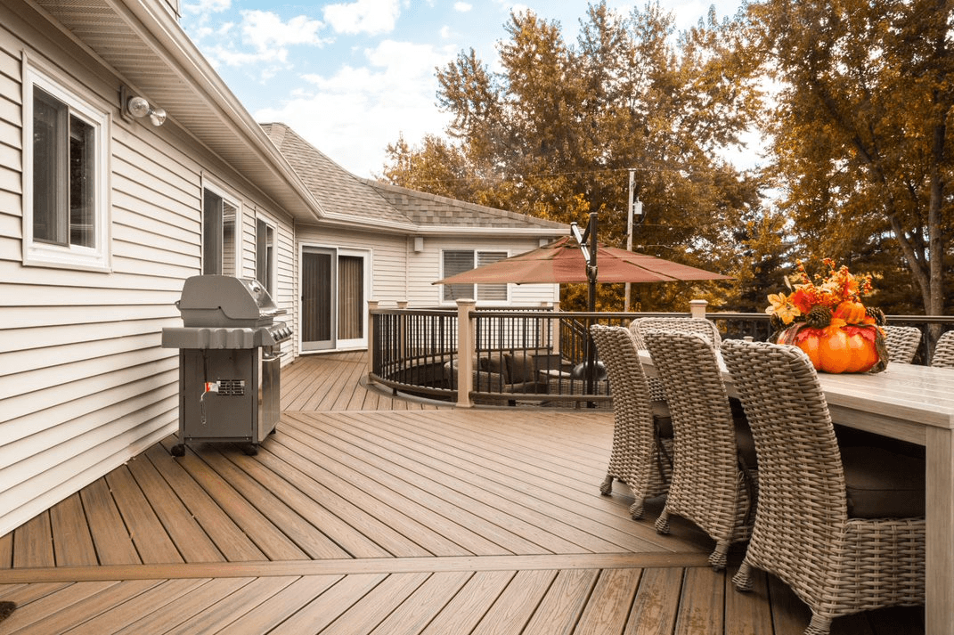 Outdoor deck with grill, dining area, and umbrella