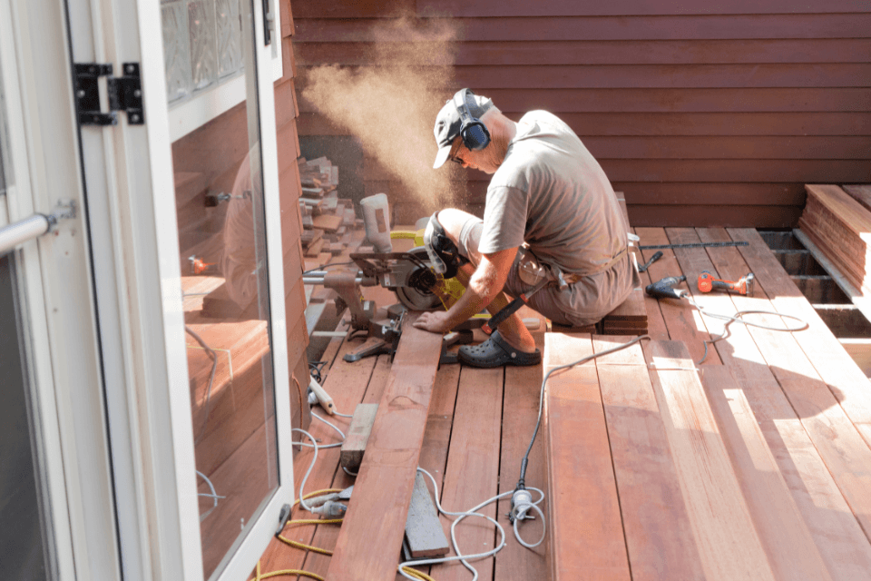 how to budget for you self managed deck build contractor sawing decking boards custom built michigan
