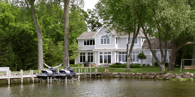 lake house ideas for your northern michigan home pier with jet skis in front of two story property custom built boyne city